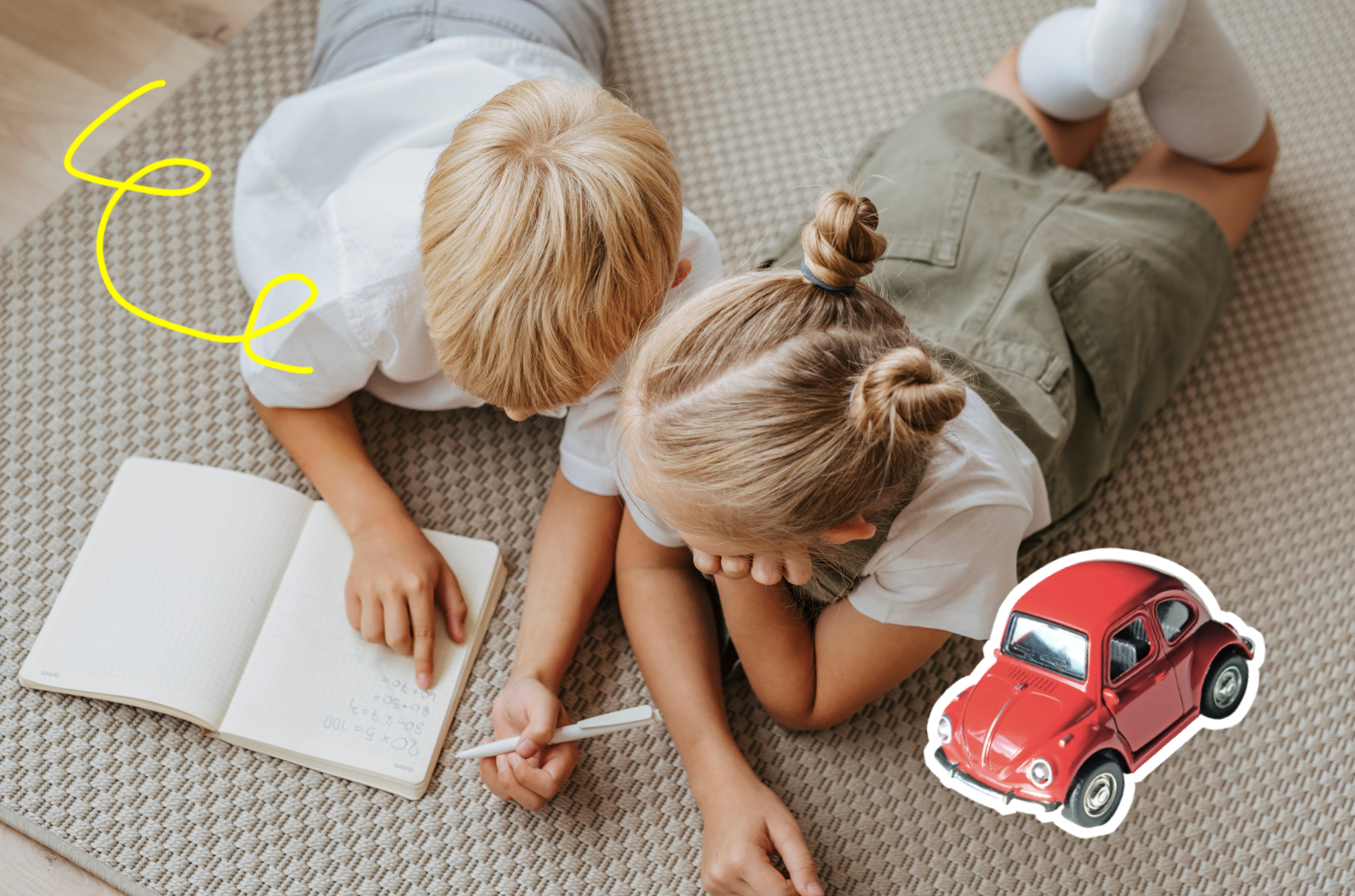 Two children lying on stomachs looking at a book